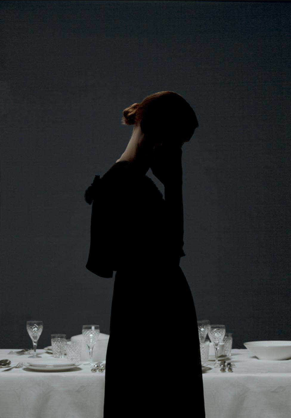 A lady in old-fashioned clothing in front of a table