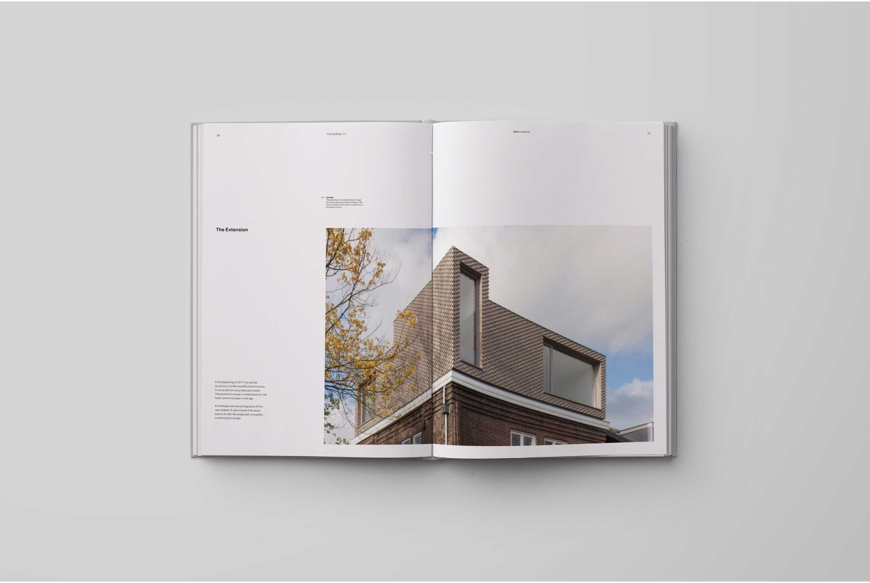 A book spread on a grey background that shows a photo of a house extension