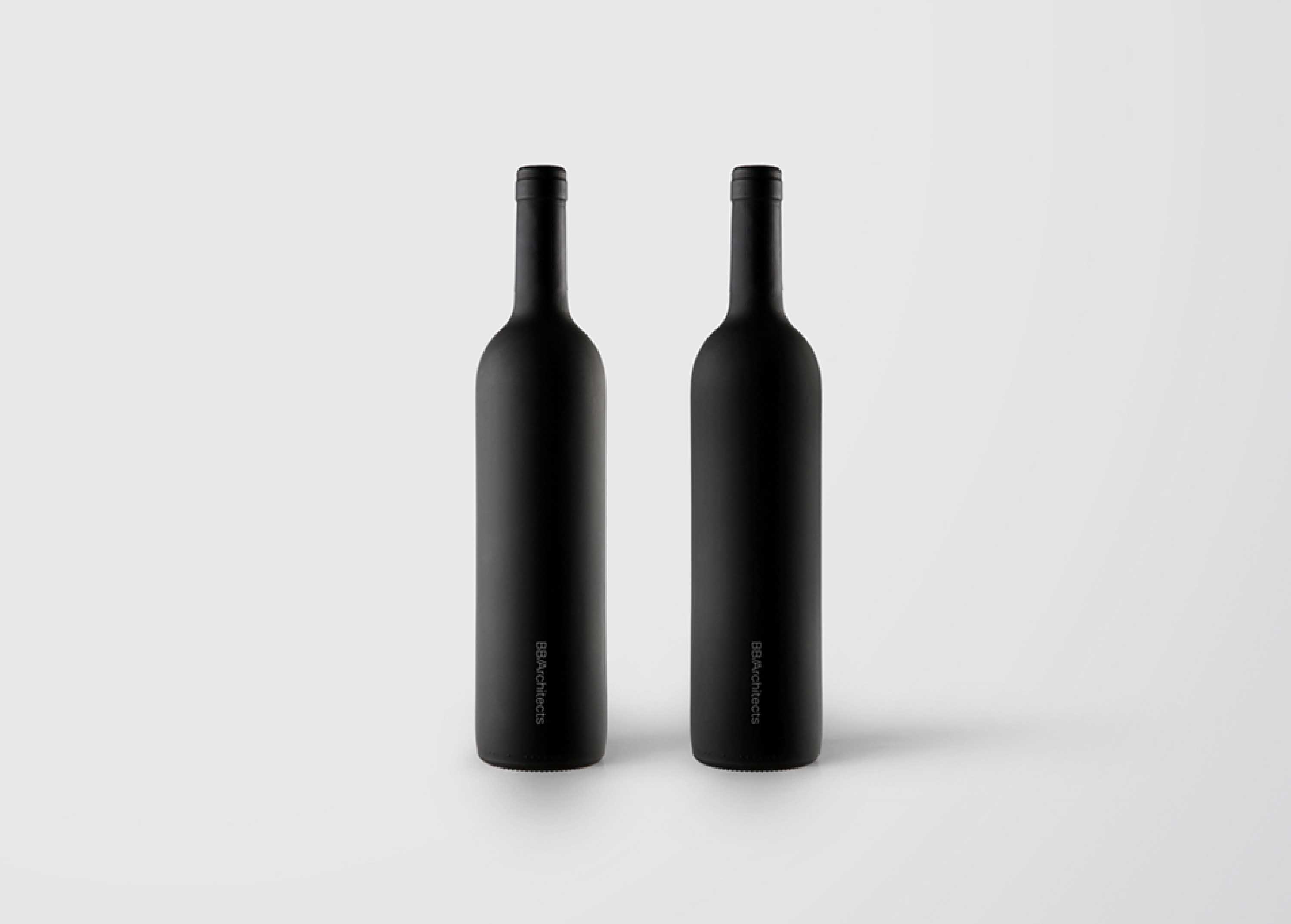 Two black wine bottles on a grey background showing the BB/Architects logo