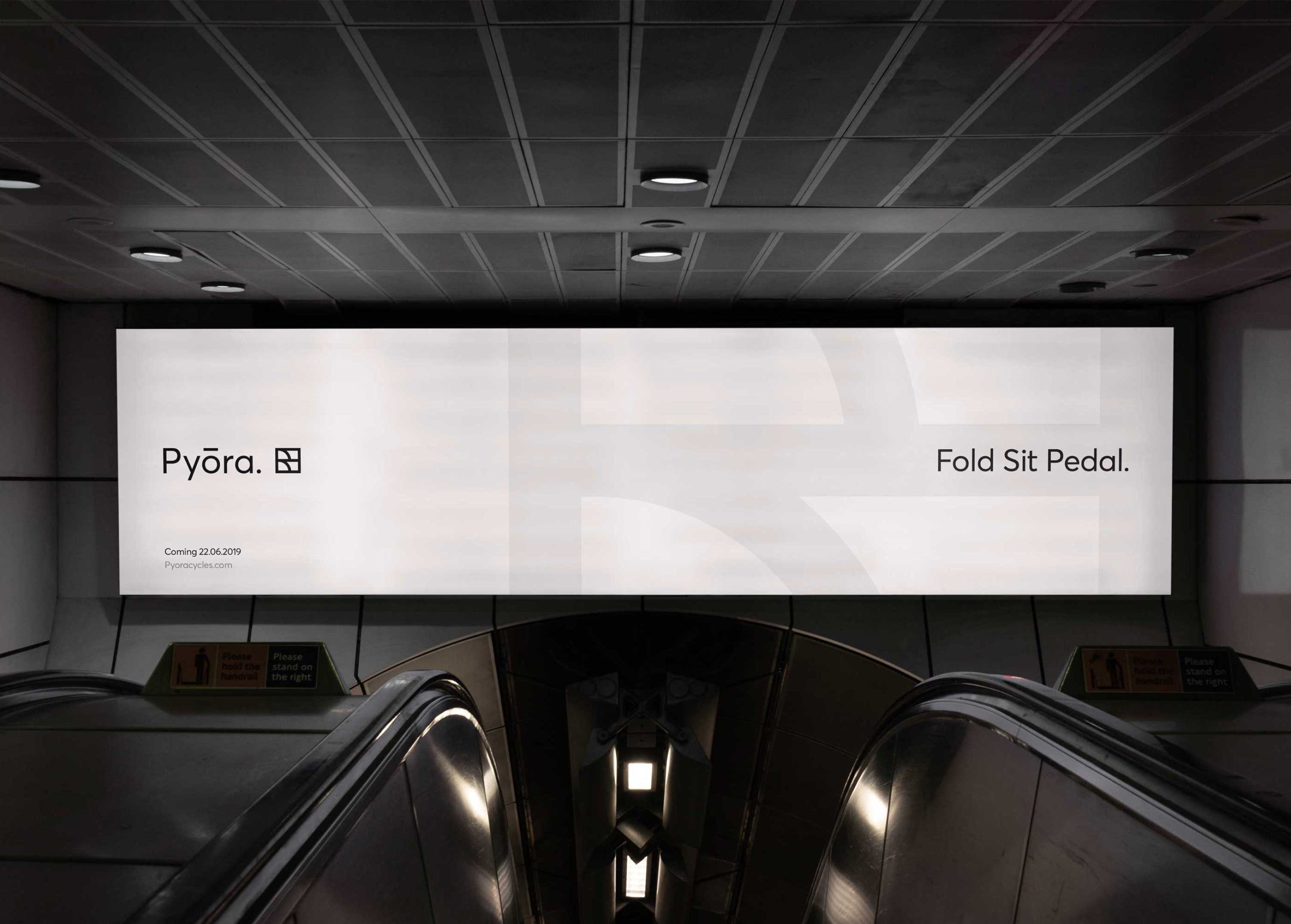 A billboard at the top of an escalator showing the Pyora brand identitiy.